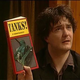 A still from Black Books in which Dylan Moran is holding a book titled "TANKS!"